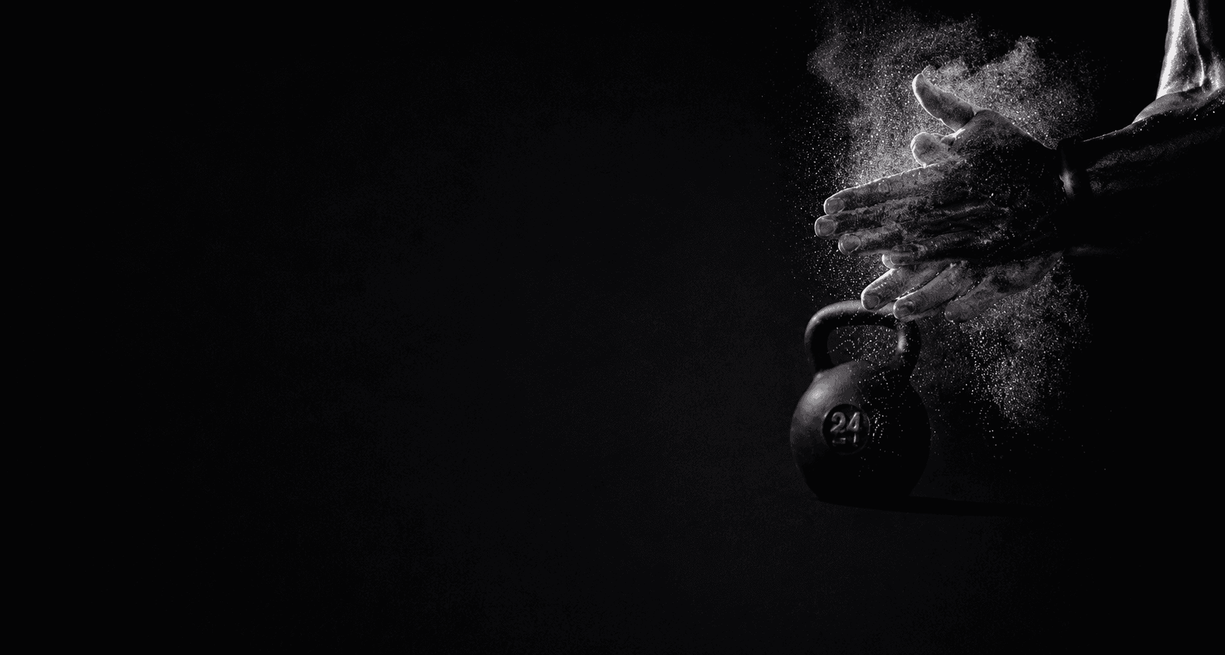 Athlète claquant ses mains couvertes de magnésie au-dessus d'une kettlebell de 24 kg